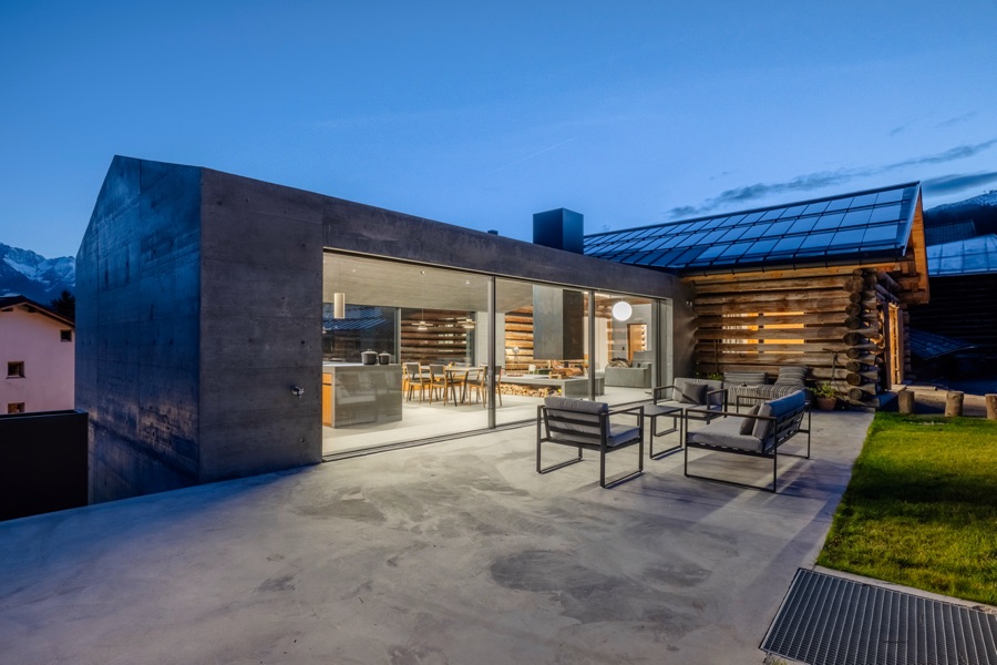 Casa Sogn Martin am Abend, Glasfront des Neubaus beleuchtet