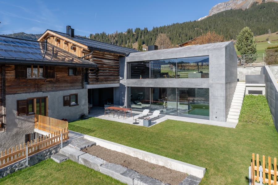 Casa Sogn Martin in Graubünden: Stall von 1826, Neubau und Wohnhaus vor den Bergen