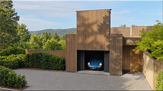 Offenes Hubtor von Delfosse an einem Haus am Hang, in der Garage ein klassischer Sportwagen