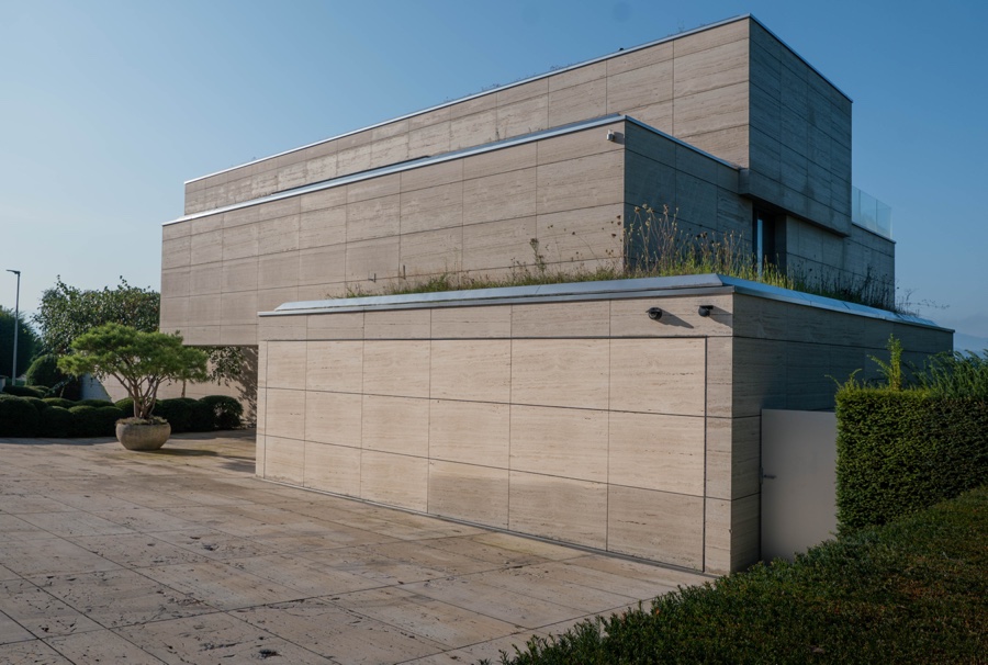 Geschlossene Garagenfront aus Travertin, eine Linie mit der Fassade