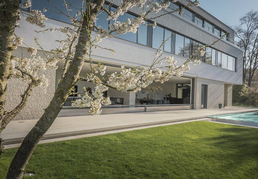 Kirschblüte vor einer Villa mit Glasfronten